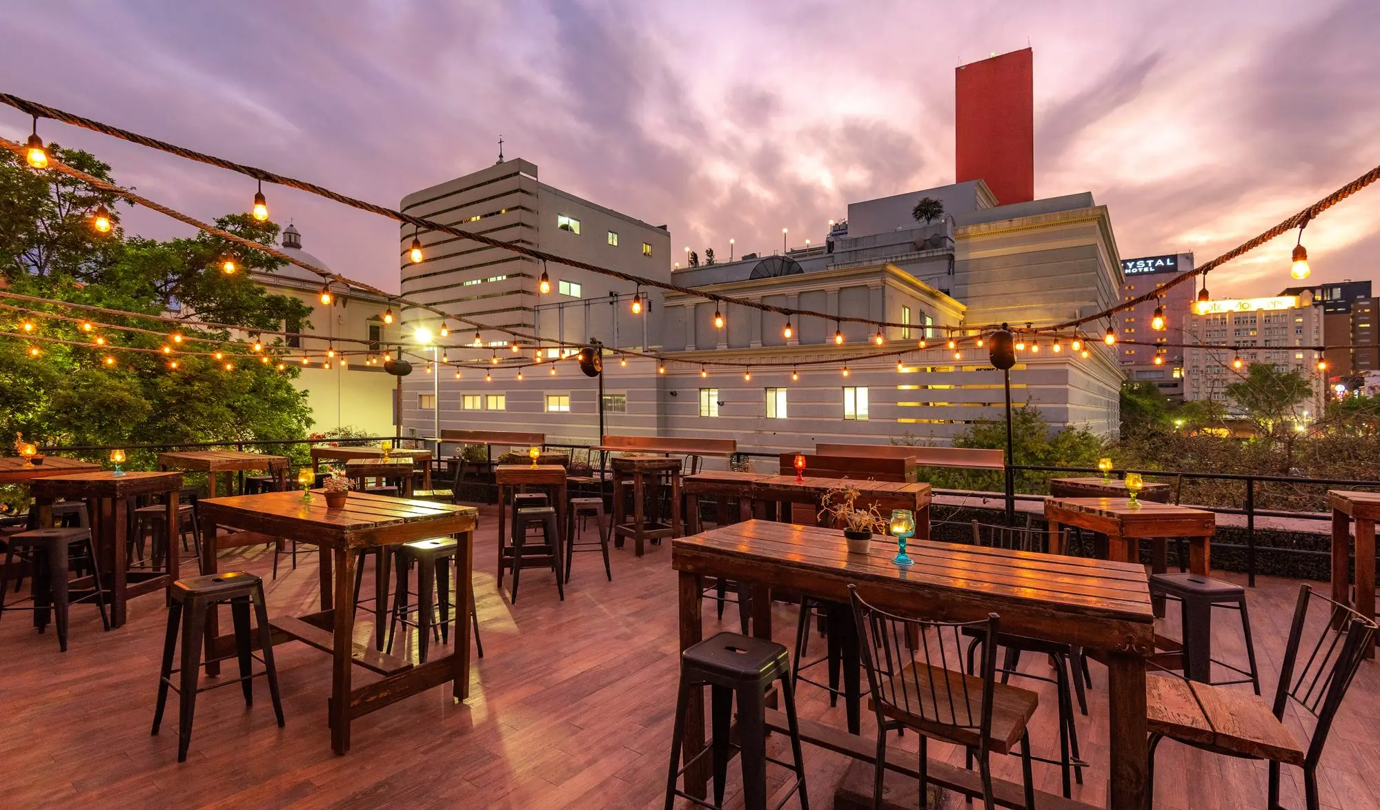 Terraza Coss at sunset, with the high tables and the city behind
