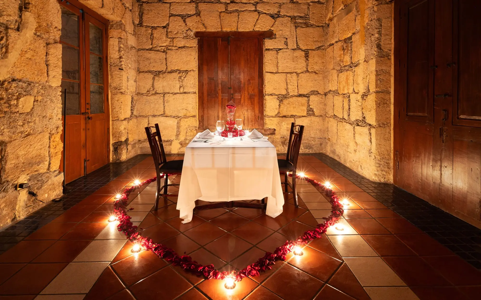 Salón del Jefe in a romantic setup, with the heart of petals and candles on the floor