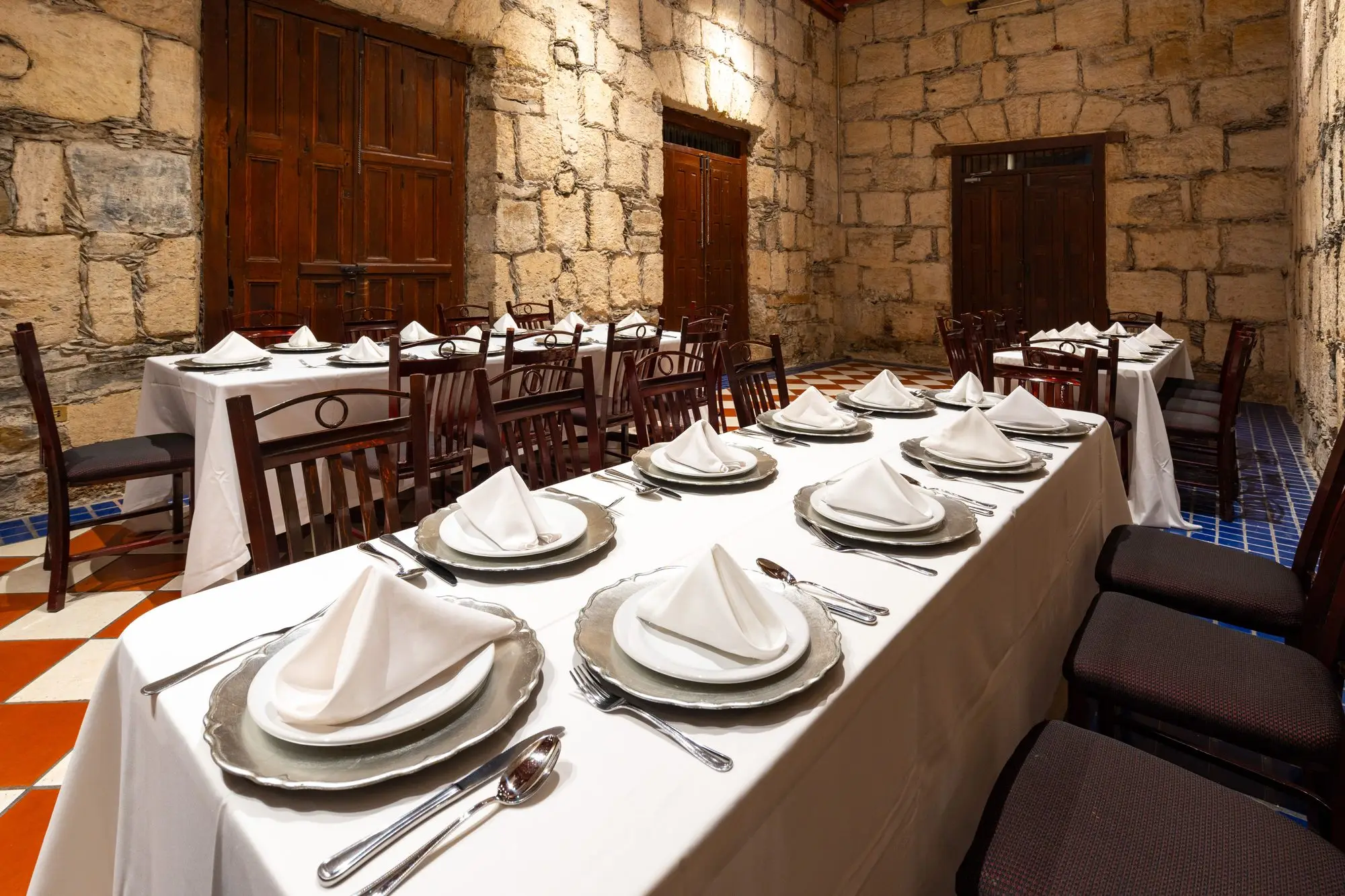 A close-up of the cutlery and napkin on the long table of Salón Romancera