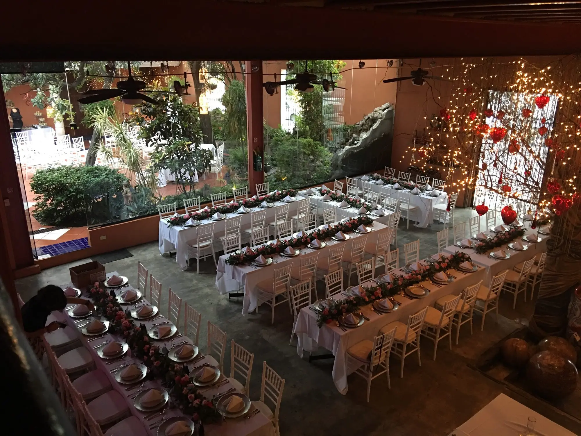 An imperial table in the Main Dining Room, with Chiavari chairs and the garden behind