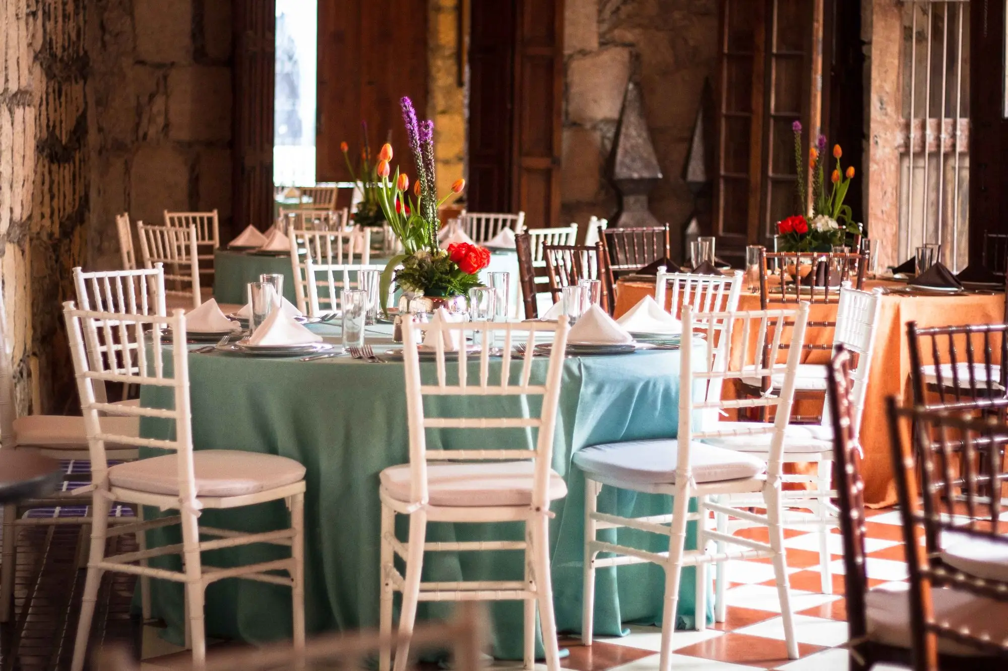 Round tables with seafoam linens and Chiavari chairs in Salón Romancera