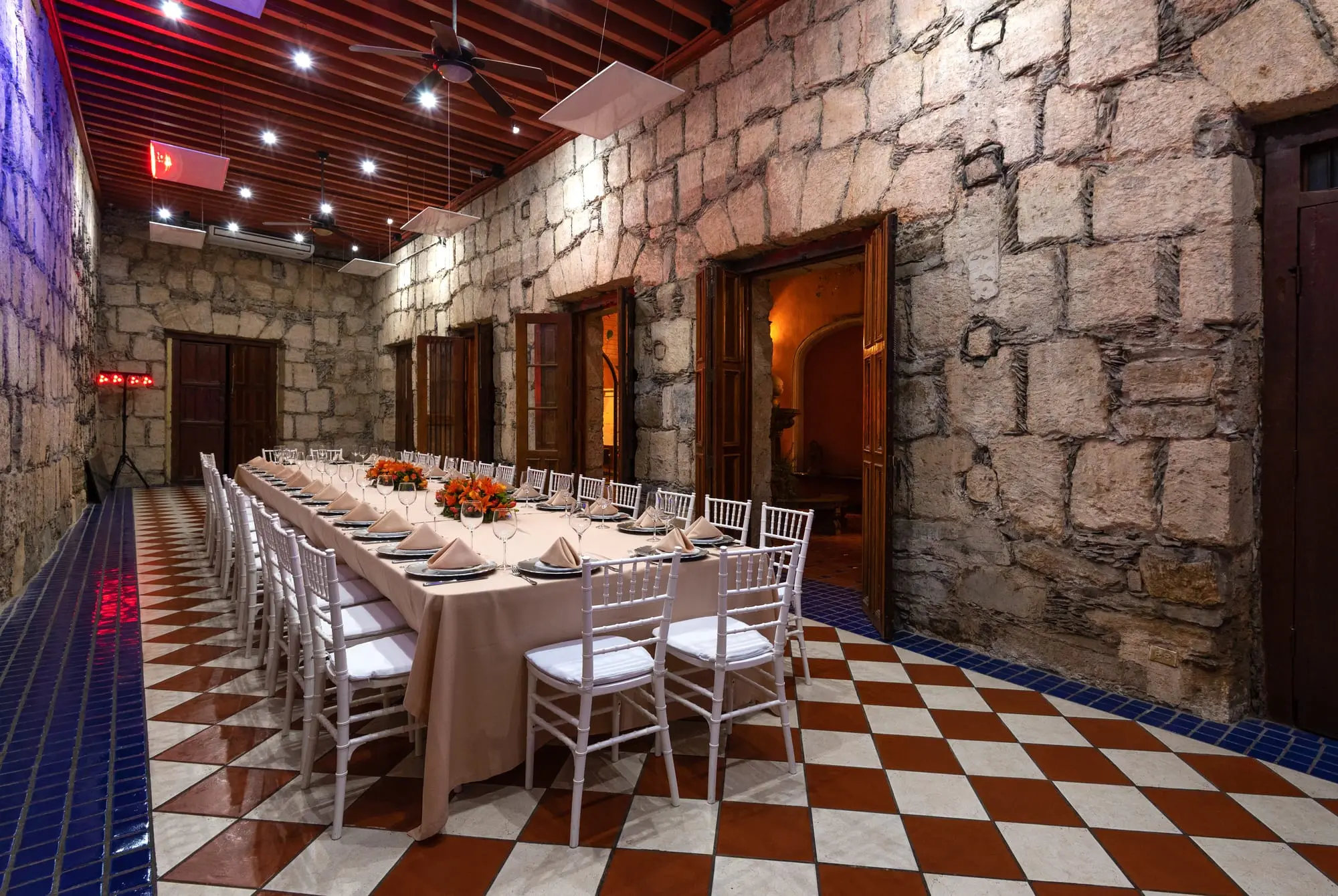 An imperial table set in Salón Romancera, with floral centerpieces on the checkerboard floor