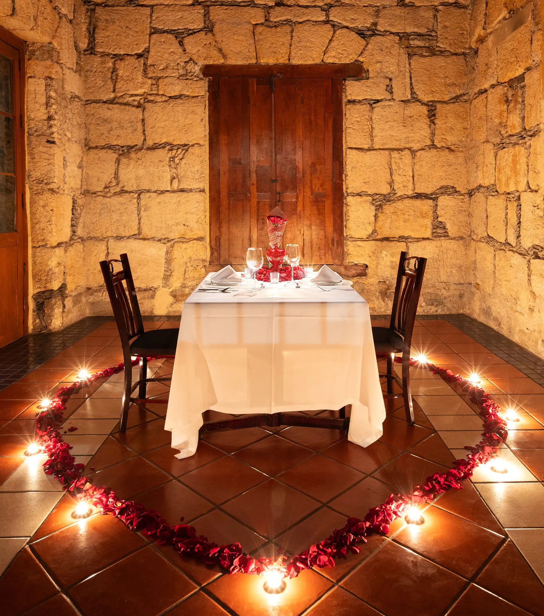 A romantic setup with a heart of petals and candles