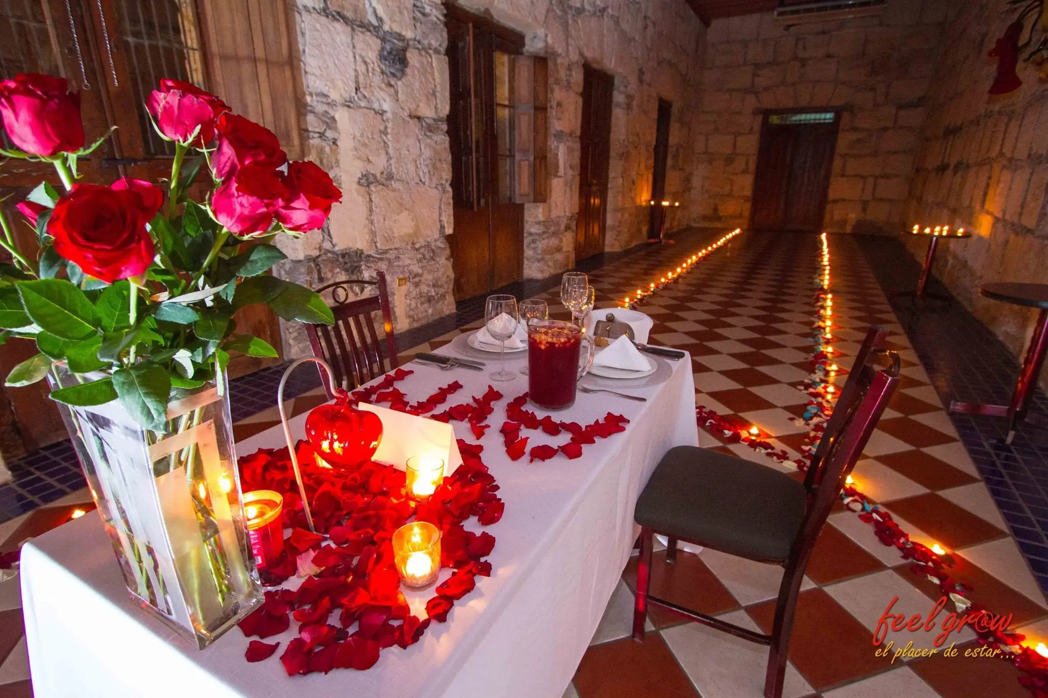 The table with roses and petals, and the candle path leading to the back of the room